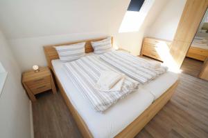 卡罗利嫩西尔Ferienhaus Lüttje Krabbe的卧室配有带条纹床单的大型白色床