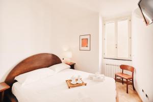 欧斯佩达蒂Appartamento fronte mare a Ospedaletti by Wonderful Italy的卧室配有白色的床和椅子