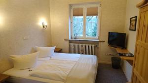 巴特利本施泰因Die Kapelle Bed & Breakfast的卧室配有一张白色大床和电视。