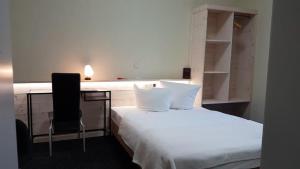 巴特利本施泰因Die Kapelle Bed & Breakfast的一间卧室配有一张带桌子和椅子的床
