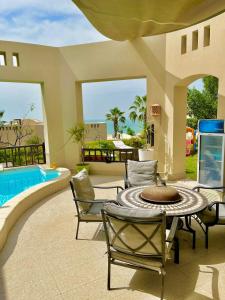 拉斯阿尔卡麦Private guest house in five stars resort的一个带桌椅的庭院和一个游泳池