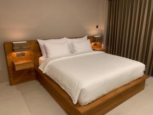 坎古Sandat Living的卧室配有一张带白色床单和枕头的大床。