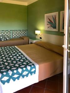 桑皮耶里iGV Club Baia Samuele的一间卧室设有一张床和绿色的墙壁