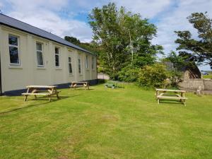 赫姆斯代尔Helmsdale Lodge Hostel - all rooms en-suite的两张野餐桌,位于建筑物旁边的院子内