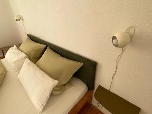 罗拉赫annadaly Stadtraumwohnung的一张带枕头的床和墙上的灯