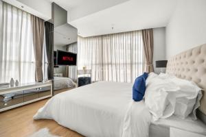 雅加达Castille by Kozystay - Gandaria的卧室配有一张白色大床和电视。