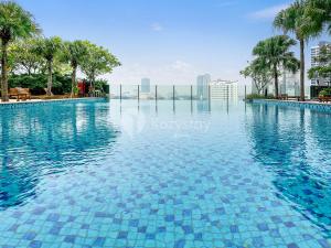 雅加达Castille by Kozystay - Gandaria的一座拥有蓝色海水和棕榈树的游泳池