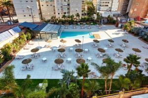 贝尼多姆沙丘套房酒店的享有带桌椅的游泳池的顶部景致