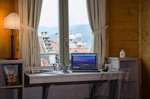 都灵Turin Sweet Home的坐在窗前的桌子上的笔记本电脑