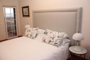 费雷拉斯Villa Tranberg Suites的卧室配有带枕头的白色床和窗户。