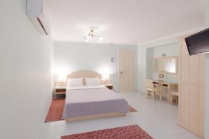 纳夫普利翁999豪华酒店的白色卧室配有床和书桌