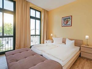 塞巴特阿尔贝克Strandvilla Ostpreussen - Dependance Strandhus的卧室配有一张白色的大床和一张沙发。