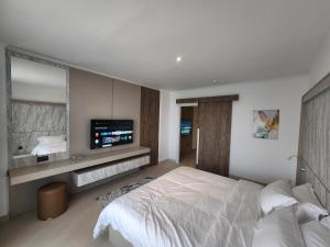 麦纳麦帝国套房酒店的一间卧室配有一张床和一台电视