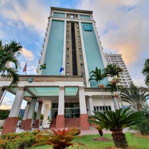 里约热内卢里约热内卢巴拉达蒂茹卡品质酒店 的一座高大的建筑,前面有棕榈树