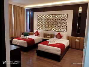 甘托克Ramada by Wyndham Gangtok Hotel & Casino Golden的酒店客房,配有两张带红色床单的床