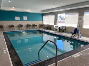德斯普兰斯avid hotels - Chicago O Hare - Des Plaines的一个带桌椅的大型游泳池
