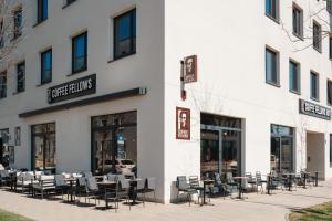 慕尼黑Coffee Fellows Hotel München-Freiham的大楼外带桌椅的餐厅