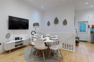 伦敦Lovely 2 Bedroom Apartment near Highgate Station的一间带桌椅和电视的用餐室