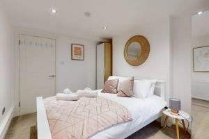 伦敦Lovely 2 Bedroom Apartment near Highgate Station的白色的卧室配有一张白色的大床和镜子