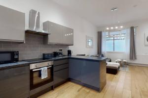 伦敦Lovely 2 Bedroom Apartment near Highgate Station的一间带不锈钢用具的厨房和一间客厅