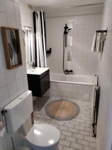 艾默伊登Ons Strandhuis的浴室配有卫生间、浴缸和水槽。