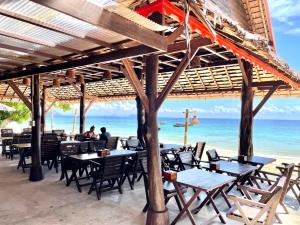 皮皮岛皮皮岛休闲海滩度假酒店的海滩上的餐厅,配有桌椅