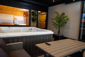 塞格德Arena Deluxe & Spa的带浴缸、桌子和植物的浴室