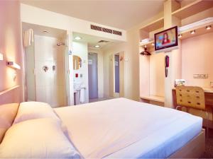 布加勒斯特加拉北站您好酒店的一间带白色大床的卧室和一间浴室