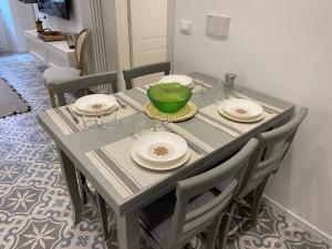 瓦拉泽Suites 5 Stelle nel Borgo di Varazze的一张餐桌,上面有盘子和一碗绿色的碗