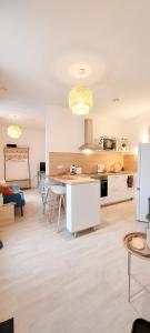 蒙吕松Artpink - Idéal Pros - Proche commerces - Agathor的客厅设有厨房和桌子
