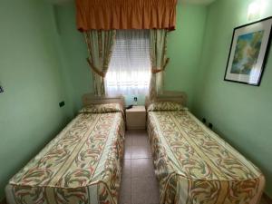 萨洛APARTAMENTO CERCA DEL PASEO Y PORT AVENTURA的小型客房 - 带2张床和窗户