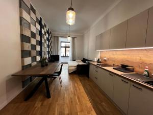 卢布林Apartamenty Rynek 5的厨房以及带桌子和沙发的客厅。