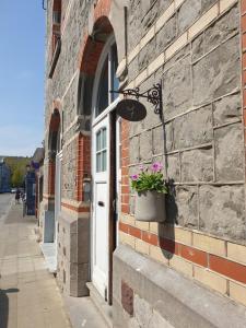 普罗丰德维耶Escale Chambre d'hôtes Au coeur du vieux Profondeville entre Namur et Dinant的砖砌的建筑,有门,上面有盆栽植物