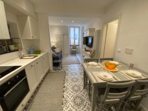 瓦拉泽Suites 5 Stelle nel Borgo di Varazze的厨房以及带桌椅的起居室。