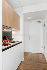 柏林SMARTments business Berlin Prenzlauer Berg的厨房配有白色橱柜和台面