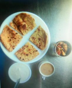 阿姆利则Hotel Sukhman Residency的桌上的薄煎饼和一盘食物