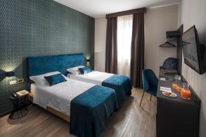 博洛尼亚阿索托丽亚酒店的酒店客房配有两张床和一张书桌