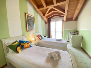 佩斯基耶拉德加达Ferretti Residence Garda Palace的一间卧室设有两张床和窗户。