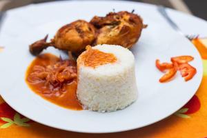 科托努Bénin Berge hotel的米饭和肉的白盘食物