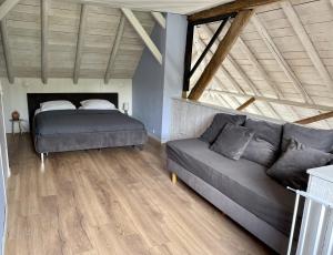 OudeschootB&B Woudzicht的客厅配有床和沙发