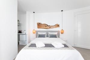 米克诺斯城Mytheo的白色卧室配有一张大白色床和两个枕头