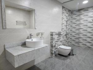 麦纳麦帝国套房酒店的白色的浴室设有水槽和卫生间。