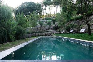 维拉·雷阿尔Casa Agricola da Levada Eco Village的花园内的游泳池,带两把椅子