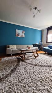 皮罗特Kingston的客厅配有桌子和蓝色的墙壁