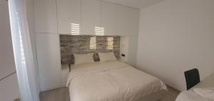 利纳迪奇Sunset holiday Krk的一间小卧室,在白色的房间里配有一张床
