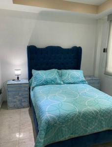 墨西哥城Depa Frente al aeropuerto 8huespedes 103的一间卧室配有蓝色的床和床头柜