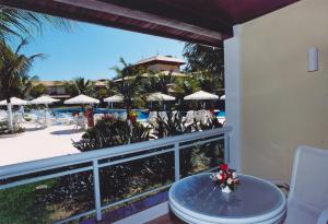 布希奥斯Hotel Atlântico Búzios Convention的阳台配有桌子,享有度假胜地的景致。