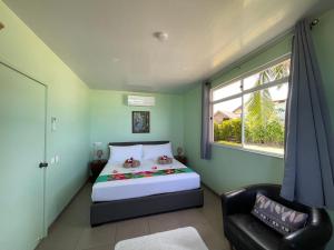 波拉波拉Matira Beach Bungalow Waterfront的卧室配有床、椅子和窗户。