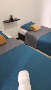 蒙特内哥罗VACACIONES a 3 km del Parque del Cafe的一间设有三张床的客房,配有蓝色和灰色