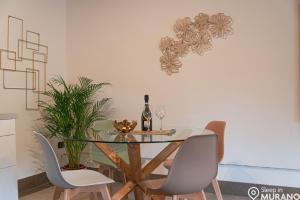 穆拉诺MURANO Place - RIVA House的餐桌、两把椅子和一瓶葡萄酒